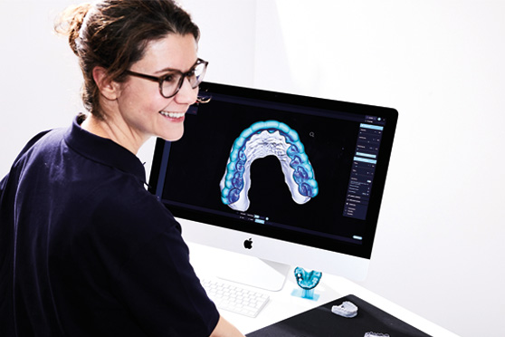 Uma funcionária de laboratório trabalha com o software DentaMile connect